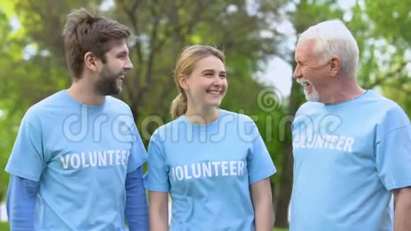 三个快乐的积极分子在志愿者T恤衫拥抱生态项目的成就视频的预览图