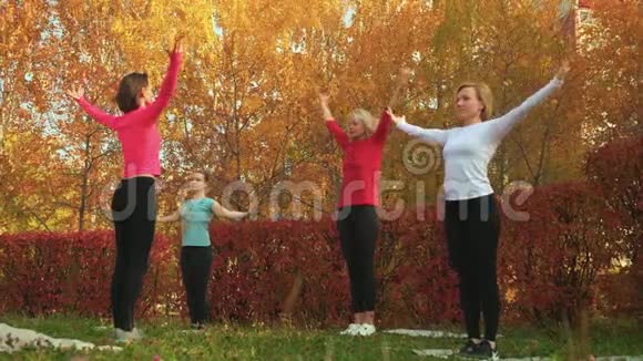 女子团体在秋季公园练习瑜伽放松的女人训练瑜伽体式户外锻炼妇女视频的预览图