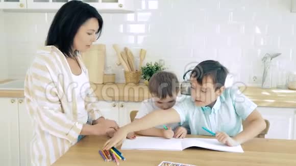 年轻的母亲和她的两个儿子在家里画记号视频的预览图