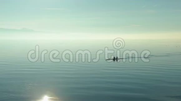 两个男子在阳光明媚的日子在日内瓦湖上皮划艇瑞士阿尔卑斯山视频的预览图