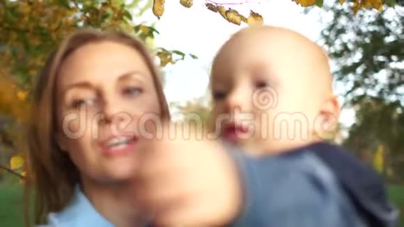 一位快乐的母亲把她一岁半的儿子抱在怀里开心地笑着妈妈天秋天走快乐视频的预览图