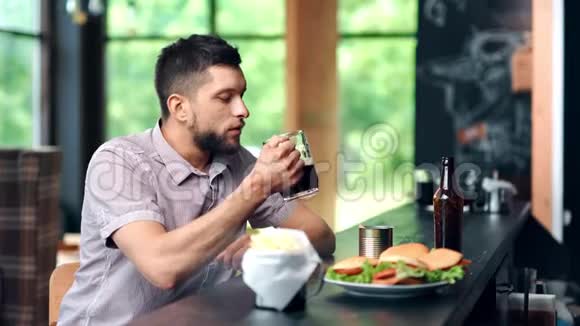 自信的男性在酒吧喝啤酒拿着杯子擦着嘴独自放松中镜头视频的预览图