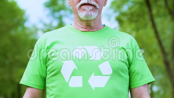 高级男性在回收符号t恤摆拍相机环境志愿服务视频的预览图