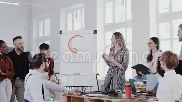 年轻的金发女老板在现代办公室会议上向员工团队解释挂图慢动作红色EPIC视频的预览图