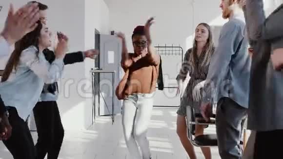 快乐有趣年轻漂亮的黑人女经理商务女性做有趣的舞蹈与办公室团队慢动作红色EPIC视频的预览图