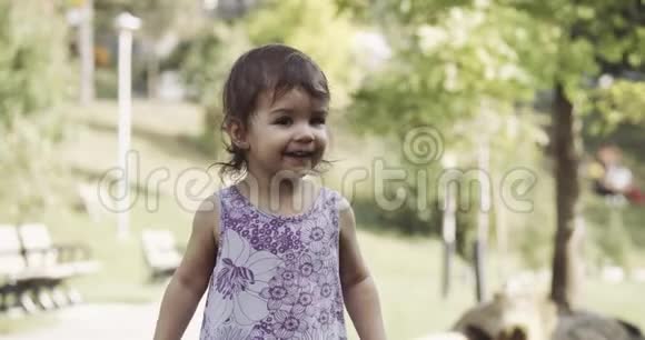 可爱的女婴在夏末探索一个公园为快乐而跳跃视频的预览图
