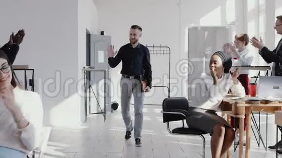 成功的中年白种人男性教练CEO进入现代办公室受到鼓掌团队慢动作红色EPIC的欢迎视频的预览图