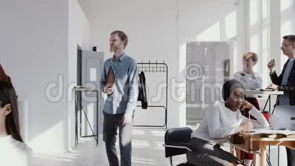 快乐年轻的欧洲男性老板走在现代办公室人们鼓掌赞扬他的成功慢动作红色EPIC视频的预览图