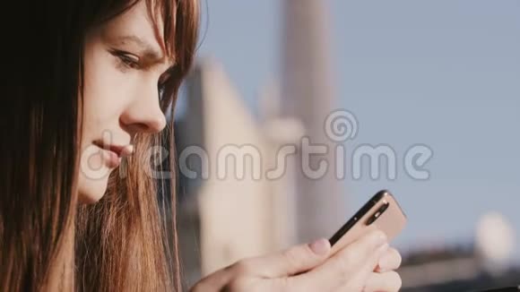 迷人的快乐女游客使用智能手机社交网络应用程序在美丽的公寓阳台度假上午视频的预览图