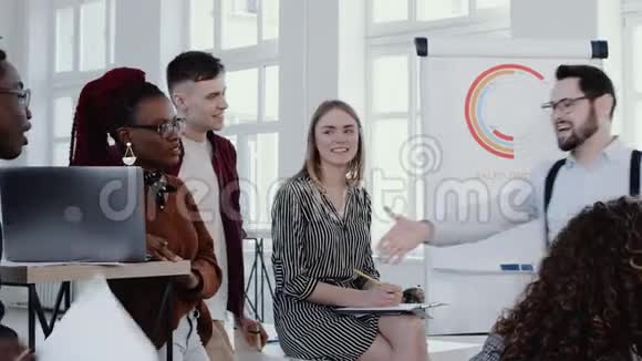 年轻的白种人老板微笑与非洲同事握手在多种族办公室团队会议慢动作红色EPIC视频的预览图