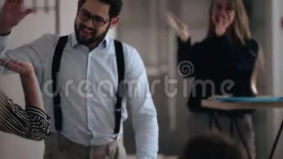 快乐的年轻白种人男性老板走在现代光办公室在事业成就后给伴侣提供高回报视频的预览图