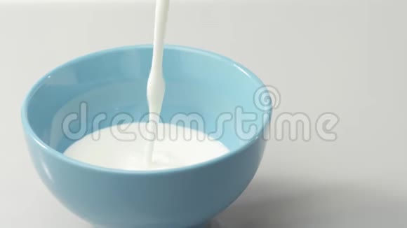 新鲜健康食品酸奶倒入蓝碗鲜果加鲜奶油有机浆果清洁饮食纯素食物视频的预览图