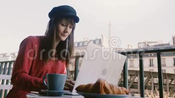 美丽优雅的女商人使用笔记本电脑在田园诗般的巴黎晨阳台享受咖啡与埃菲尔铁塔景视频的预览图