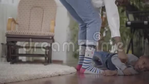 漂亮的非裔美国女人和她可爱有趣的小儿子玩把他扭在怀里妈妈视频的预览图