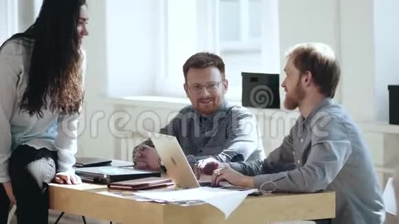 快乐轻松的年轻男老板商人与微笑的同事在现代阁楼办公室工作场所的桌子上交谈视频的预览图