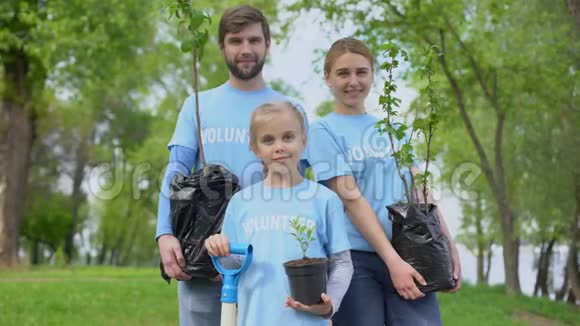 持盆栽树自然保育的义工T恤衫的家长及儿童视频的预览图