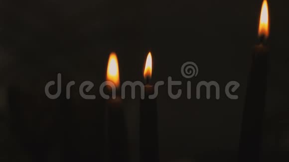 宗教节日当天三支蜡烛在黑色背景上燃烧视频的预览图