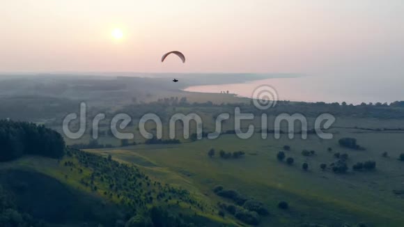 绿色的雾状风景沿着它漂流降落伞滑翔伞视频的预览图