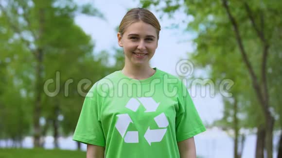 美丽的白种人妇女回收标志t恤微笑相机自然资源视频的预览图