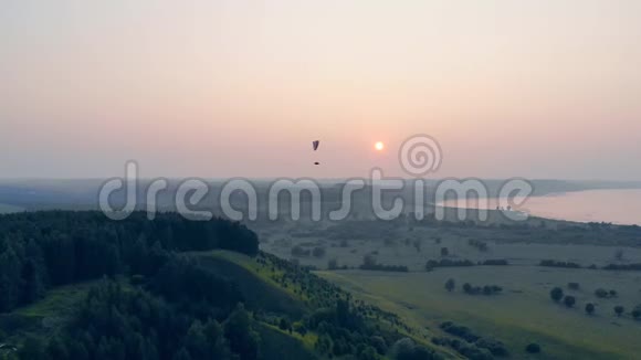 阳光明媚的景色和高高飘扬的航机空中滑翔伞视频的预览图