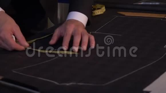 裁缝正在用粉笔在布料上画线以便做一套衣服视频的预览图