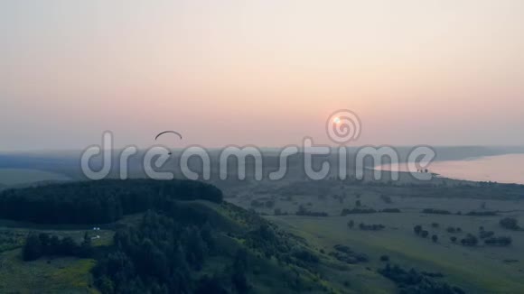 太阳落山了而矮车在天空中漂浮降落伞滑翔伞视频的预览图