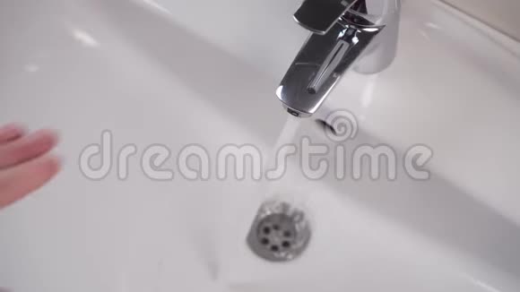 一只法力的手关上白色浴室洗手池里的水龙头自来水就停止了视频的预览图