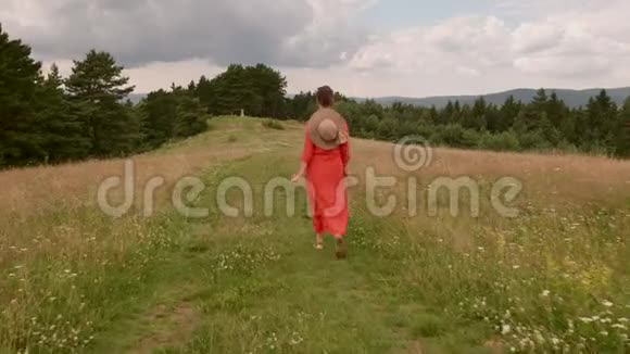 女子行走在山顶森林道路上镜头跟随视频的预览图