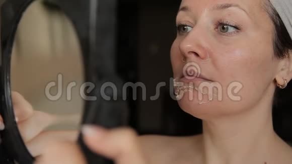 皮肤有问题的女孩照镜子脸上的片状皮肤视频的预览图