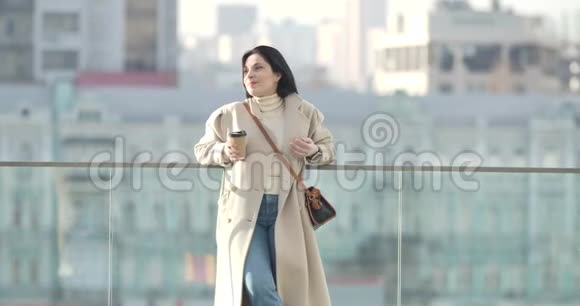 自信的白种人女人穿着优雅的米色外套在城市里休息的肖像年轻成功的商人视频的预览图