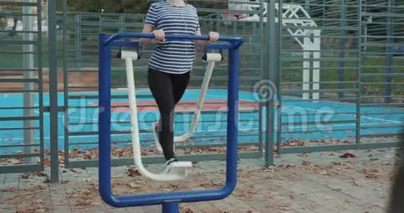 锻炼户外健身器材在健身房锻炼的女人秋季时间户外活动视频的预览图