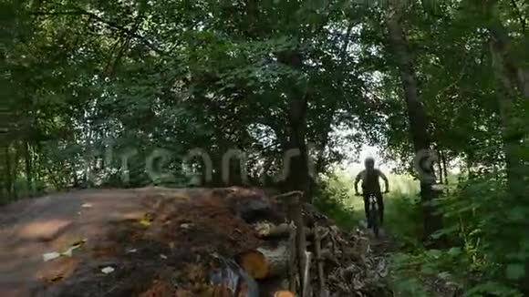 骑自行车的人戴着安全帽骑着山地车在森林的跳板上骑着视频的预览图
