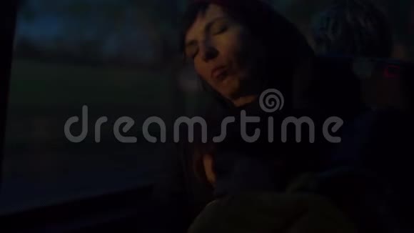 一个女人一大早就睡在公共汽车椅子上在黑暗中视频的预览图