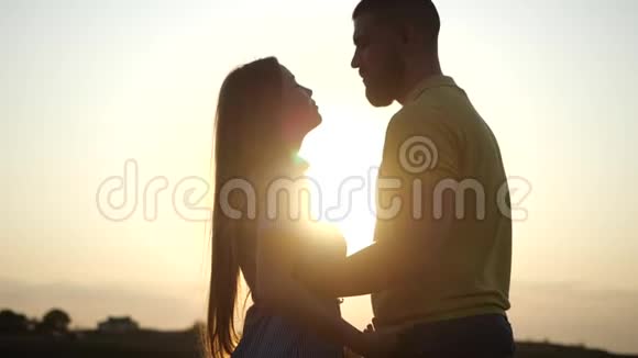 一对年轻迷人的夫妇在日落时牵手在乡村风景中的爱情故事留胡子的年轻人和视频的预览图