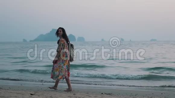 女孩背着背包走在海边视频的预览图
