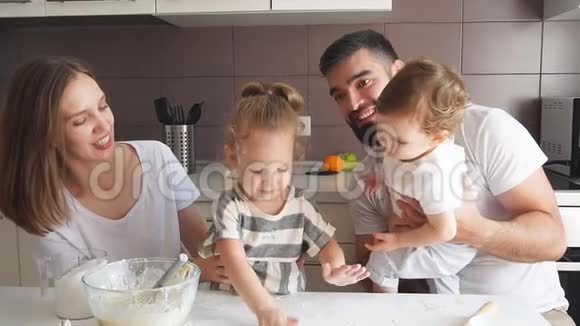 快乐微笑的夫妇和他们的孩子做美味的蛋糕视频的预览图