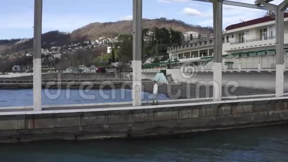 在现代城市高地的海上码头上漫步的空中观景人视频的预览图