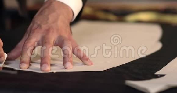 一个裁缝用粉笔在布料上画线条并在剪裁周围做一些改动视频的预览图