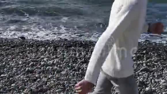 快乐的人在卵石滩上奔跑海水缓慢运动视频的预览图