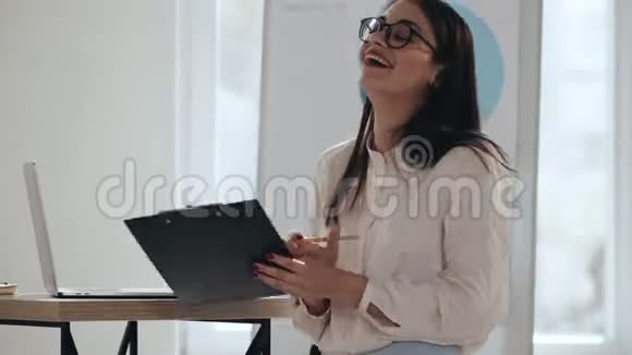 快乐年轻成功的高加索女教练鼓掌微笑着在现代轻办公室活动中讲话视频的预览图