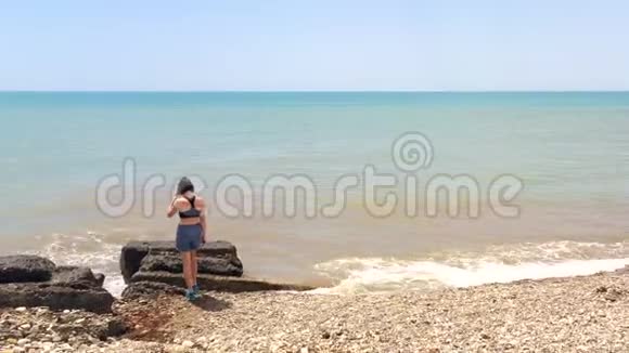 海滩攀岩的孤独女孩视频的预览图