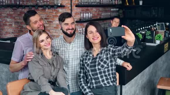 在爱尔兰酒吧一群不同的年轻人用智能手机自拍视频的预览图