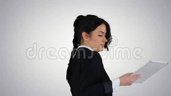 快乐的年轻女子跳舞听音乐在平板电脑上的梯度背景视频的预览图