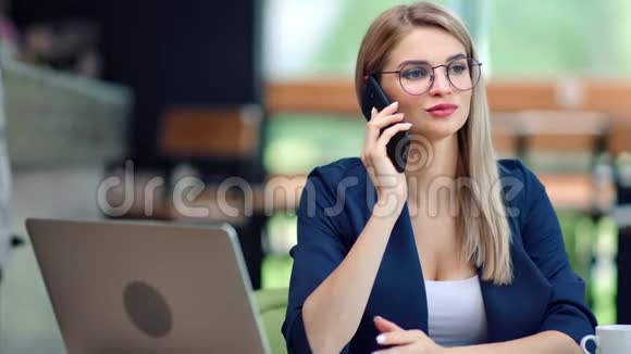 可爱的时尚女商人用智能手机说话在现代办公室有积极的情绪视频的预览图