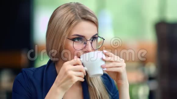 漂亮的商务女性从杯子里喝咖啡放松享受休息中等特写视频的预览图