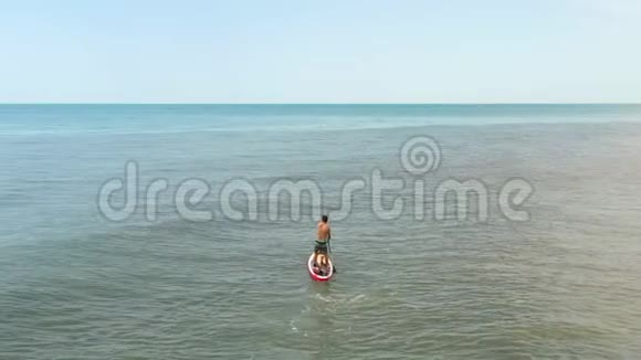 在无边无际的蔚蓝海中年轻夫妇漂浮在波浪上向地平线上伸展视频的预览图