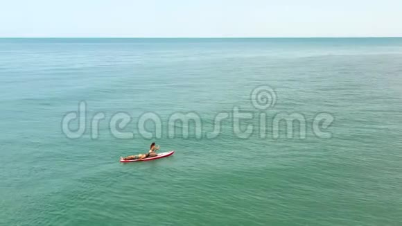 两个冲浪者漂浮在蓝绿色波浪海的冲浪板上空中圆景视频的预览图