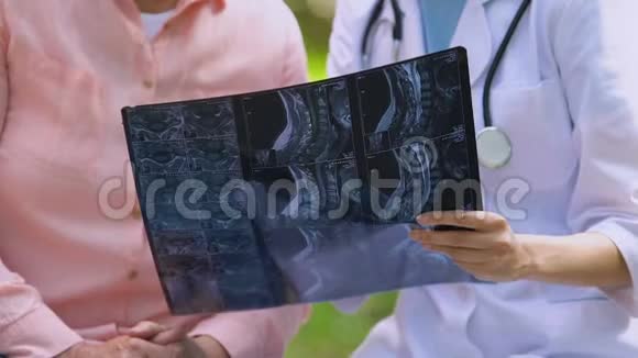 青年医生显示老年病人关节检查x光结果户外视频的预览图