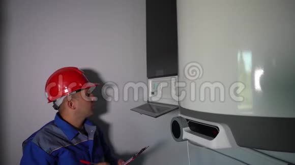 管道工把暖气锅炉放在家里对着镜头竖起大拇指微笑视频的预览图