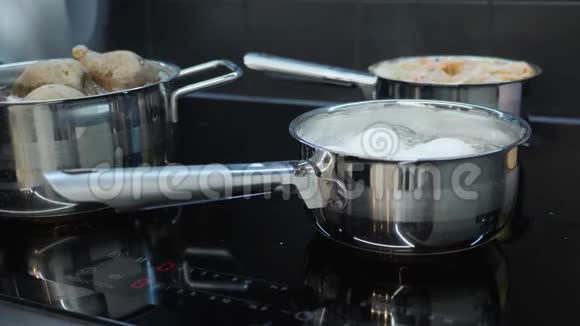 厨师从电炉上取下熟鸡蛋家庭烹饪蔬菜在感应电炉上用平底锅煮流程o视频的预览图